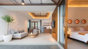 A modern hotel room with a sofa, dining table, and a bed.