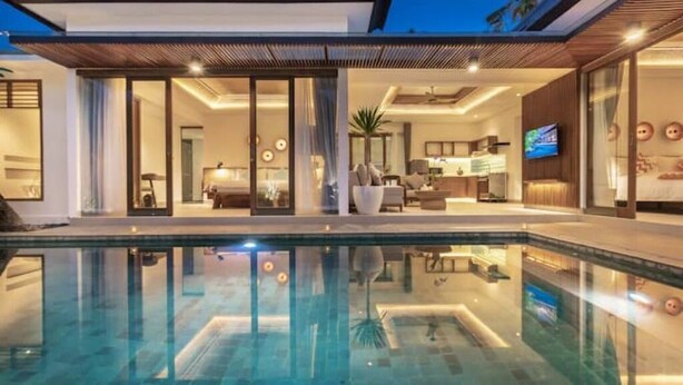 A modern house with a swimming pool, a living room, and a kitchen.