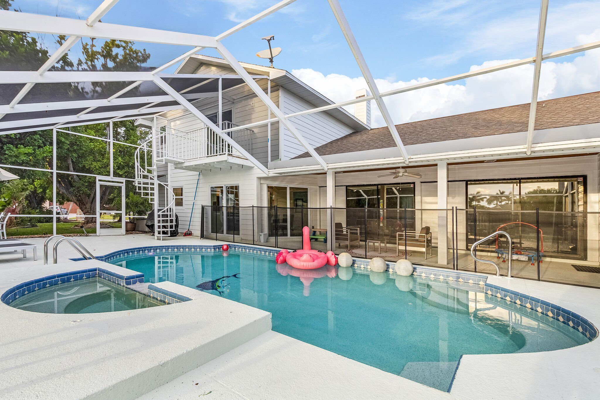 Une piscine dotée d’une terrasse fermée par des baies vitrées, d’un jacuzzi et d’un patio abrité.