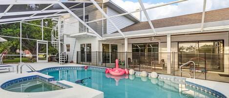 Une piscine dotée d’une terrasse fermée par des baies vitrées, d’un jacuzzi et d’un patio abrité.