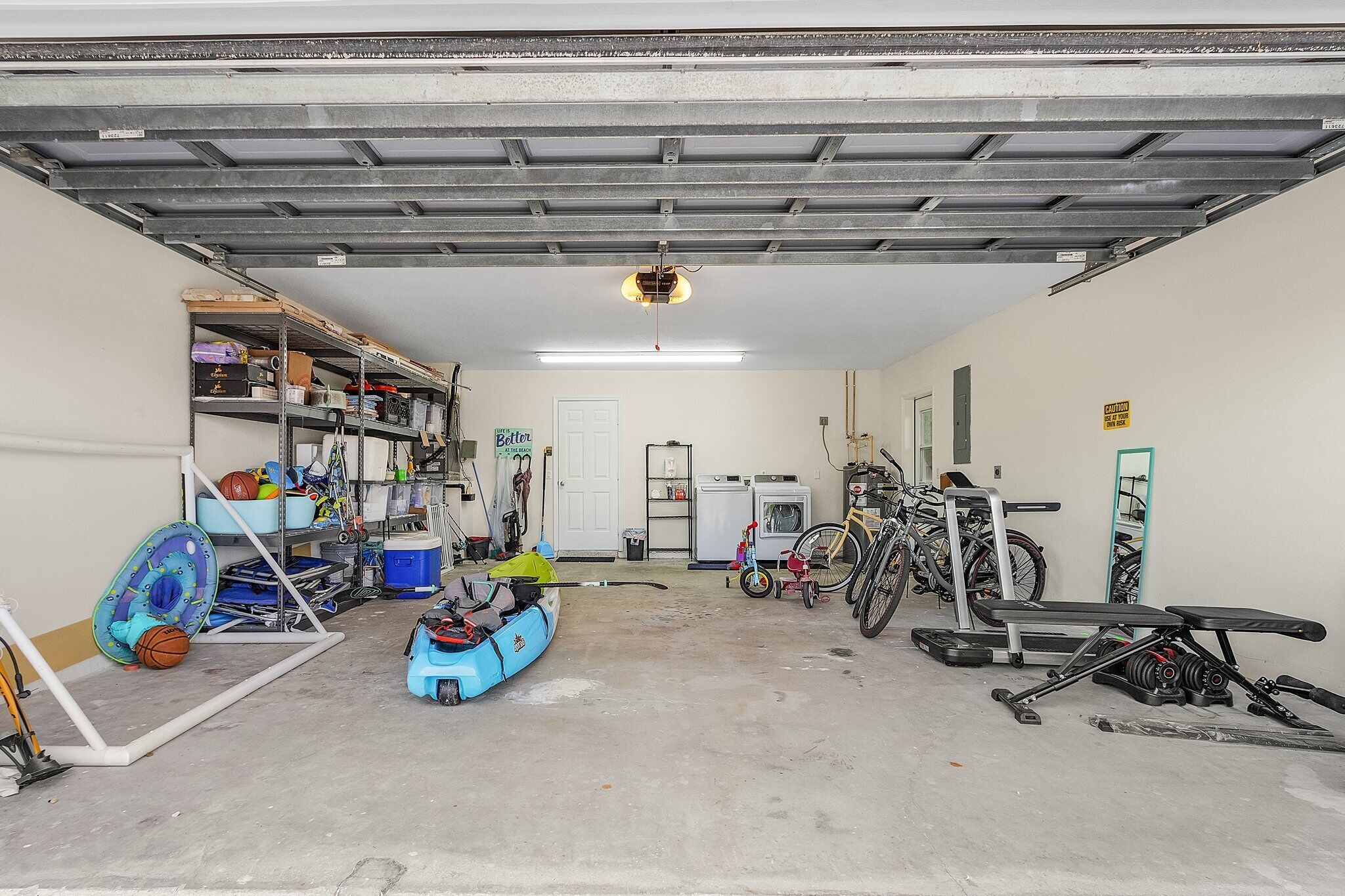 Eine Garage mit einem Fahrrad, einem Kajak und einer Bank.