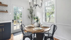 Comedor con una mesa redonda de madera dispuesta para cuatro personas, rodeada de sillas negras.