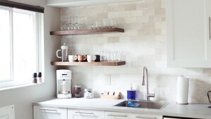 A kitchen with white cabinets, a coffee maker, and a sink. - Beautiful & Bright Townhome (Westerville)