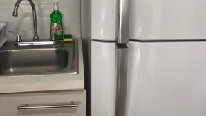 A kitchen with a stainless steel refrigerator, a sink, and a bottle of dish soap. - Studio apartment great location trendy area (Ciudad de Guatemala)