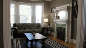 Un salon avec un canapé, une table basse, une cheminée et une lampe.