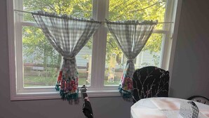 A room with a window, a chair, and a table.