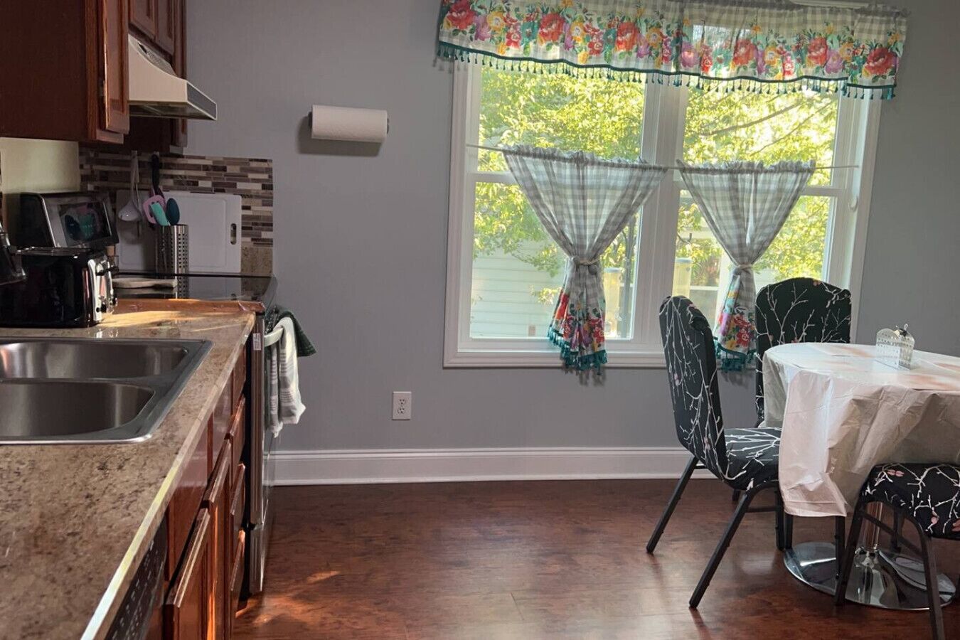 Une cuisine équipée d’un évier, d’une cuisinière et d’un coin repas avec des chaises et une table.