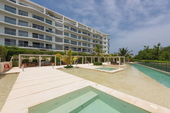 Ein Hotel mit mehreren Balkonen, einem Schwimmbad und Außenbereich-Sitzgelegenheiten.
