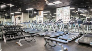 Ein Fitnessstudio mit Laufbändern, Hanteln und Kraftgeräten.