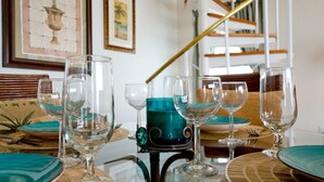 Een eettafel gedekt met verschillende wijnglazen en een blauwgroene karaf.