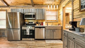 Une cuisine moderne dotée d’appareils électroménagers en acier inoxydable, de meubles de rangement en bois et d’un plafond en bois.