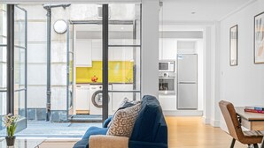 A modern apartment with a living room, kitchen, and laundry area.