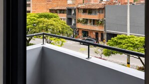 A balcony with a view of a cityscape, including buildings and a street. - Hotel Ofix - Laureles (Medellín)