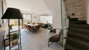 A modern interior with a dining area, a staircase, and a view of the outdoors. - Villa Black & Gold with Pool (Okrug Gornji)
