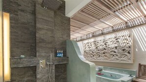 Ein Badezimmer mit Steinwand, Dusche und einem Zierteil.