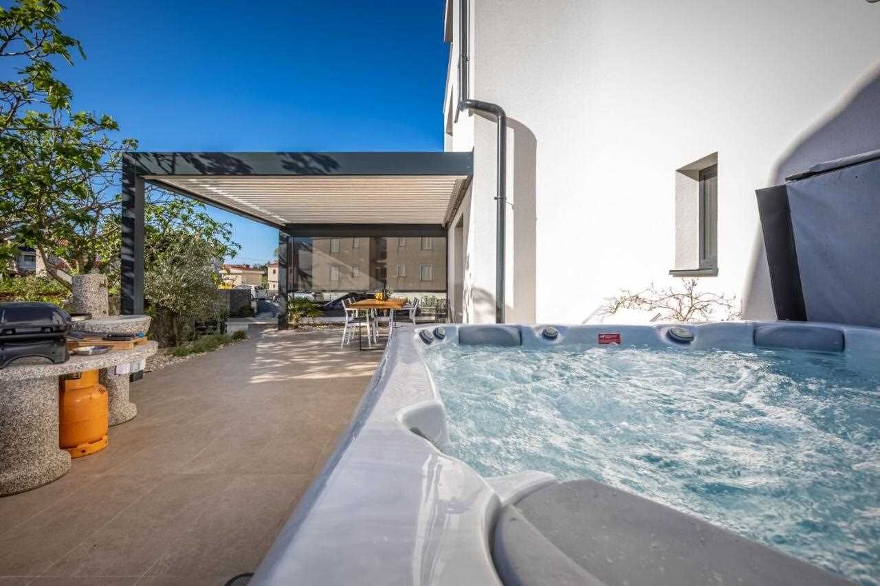 Ein Whirlpoolbereich mit überdachter Sitzgelegenheit und einer Steinbank.