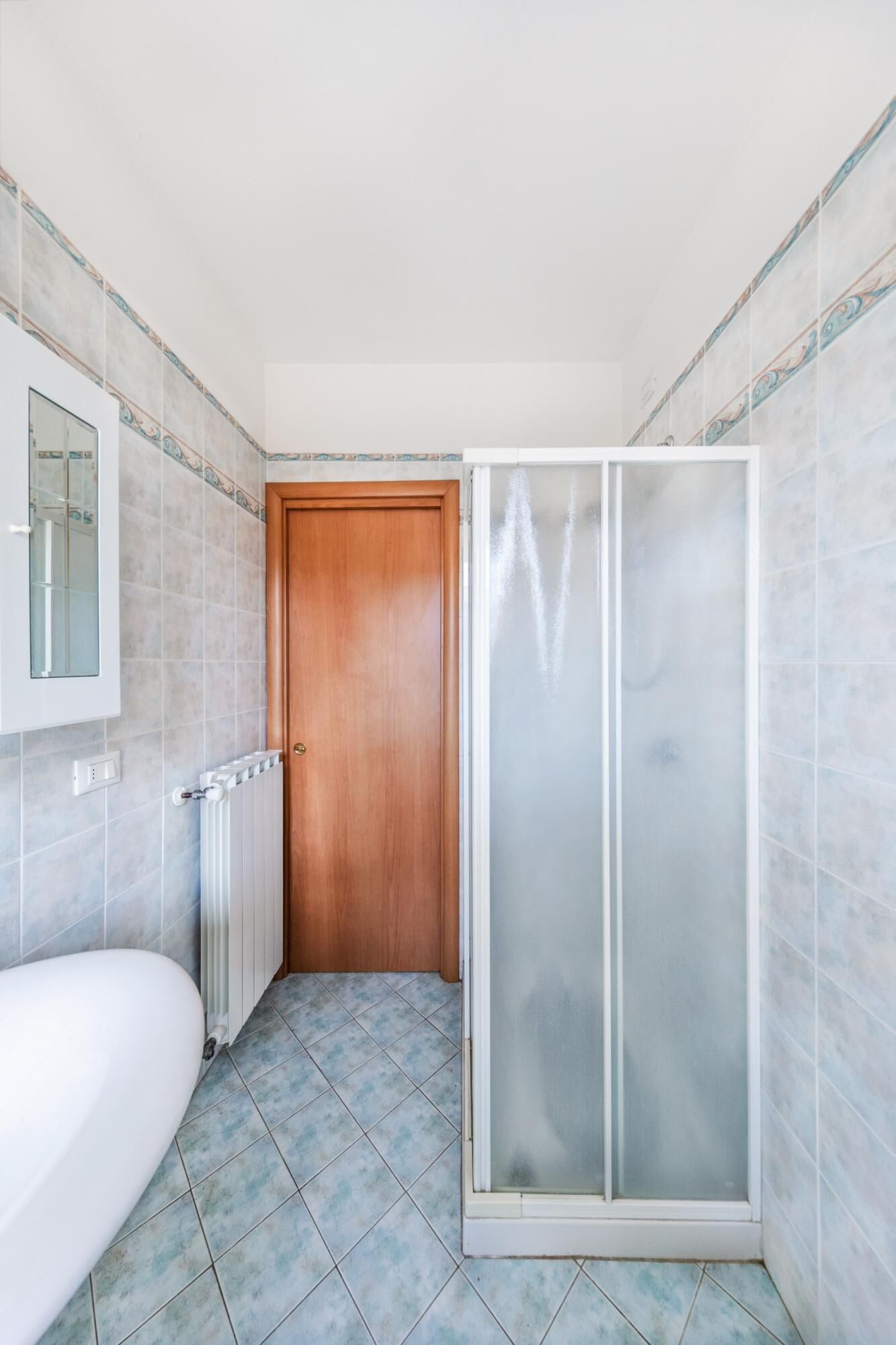 Baño con cabina de ducha, inodoro y bañera.