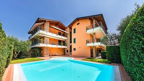 A two-story building with a swimming pool in front. - Annamaria 9 con Piscina by Wonderful Italy (Sirmione)