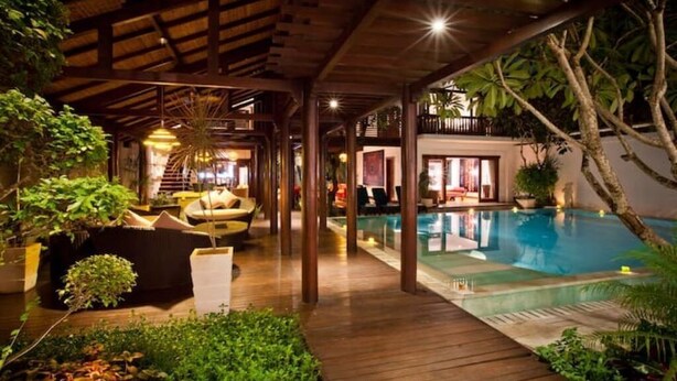 A poolside area with wooden decking, lounge chairs, and a pool. - Nice Spacious 3BR Family Villa Walk to Sanur Beach (Sanur)
