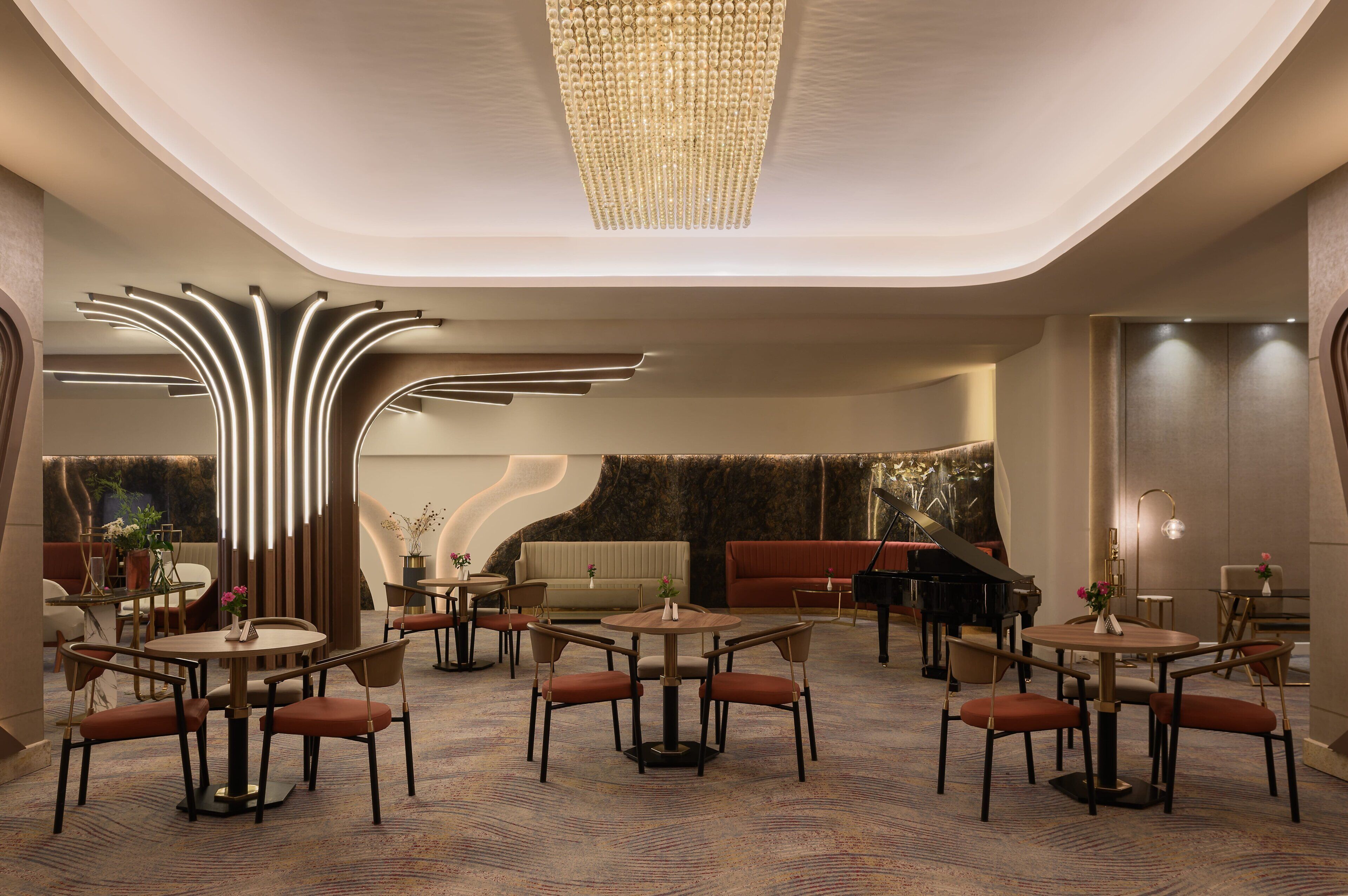 Un vestíbulo de hotel moderno con mesas y sillas redondas, un piano de cola y un diseño de techo original.