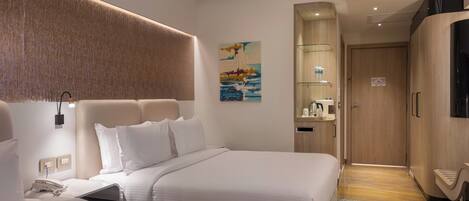A hotel room with two beds, a mounted TV, a painting on the wall, and a wooden wardrobe.