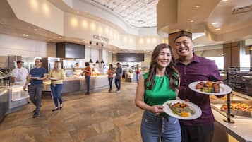 A spacious food court with a modern ceiling design and a visible 'carvery' sign.
