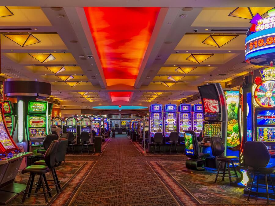 A casino with slot machines, a red ceiling, and a carpeted floor.
