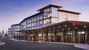 A modern hotel with a glass facade, a covered entrance, and a landscaped driveway. - Red Hawk Resort & Casino (Placerville)
