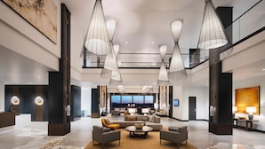 A spacious lobby with a marble floor, modern furniture, and large pendant lights. - Red Hawk Resort & Casino (Placerville)