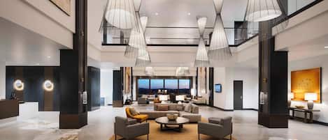 A spacious lobby with a marble floor, modern furniture, and large pendant lights.