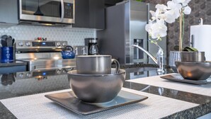 A modern kitchen with stainless steel appliances, a microwave, and a coffee maker. - 3280 - Beautiful 3br Home near Disney - The Hub at Westside (Kissimmee)