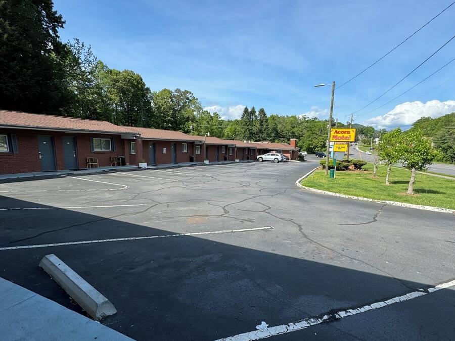 Un motel con estacionamiento y un cartel que indica 'Accomadite Motel'.