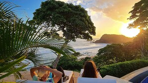 Two lounge chairs facing a pool with a view of the ocean and a sunset. - BEACHFRONT INFINITY POOL – DIRECT PRIVATE BEACH ACCESS – FOREST & TROPIC GARDENS (San Juan del Sur)