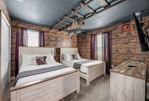 Two beds with matching headboards, bookshelves, and a desk create a cozy workspace.