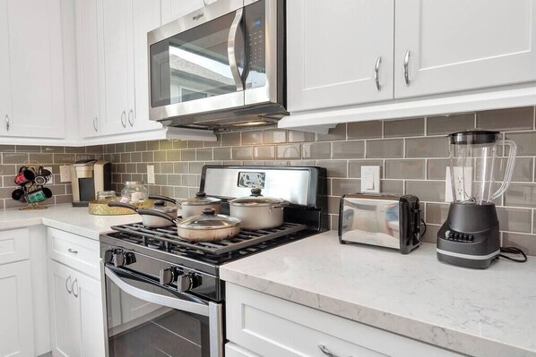 Fully equipped kitchen with gas stove, toaster, and blender.
