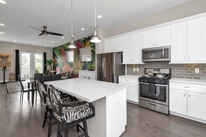 Enjoy cooking in this well-equipped kitchen with a large island, refrigerator, microwave, and oven.