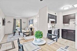 A modern apartment with a dining area, kitchen, and living room.