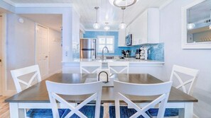 Enjoy meals in the kitchen with a central island, stainless steel appliances, and a dining area with a wooden table.