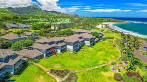 Ein Resort mit mehreren Gebäuden, einem Golfplatz und Blick auf den Strand.