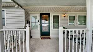 A porch with white railings and a green door, a welcome mat, and a 'Welcome' sign. - Spacious Family Retreat with Game Room 25 Mins to PCB (Lynn Haven)