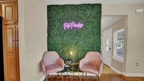 A room with a green wall covered in foliage, two pink chairs, a small round table, and a neon sign that reads "Pah Paradise". - Spacious Family Retreat with Game Room 25 Mins to PCB (Lynn Haven)