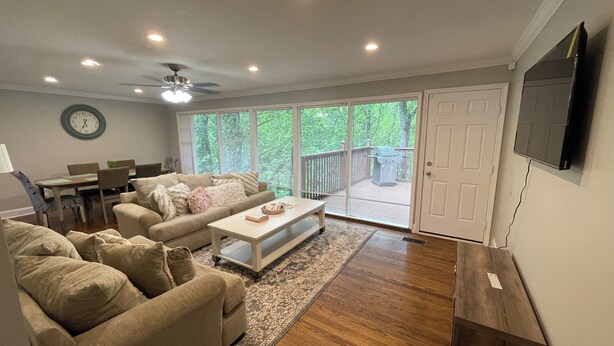 A modern living room with a sofa, coffee table, and dining area. - Nestled within the pines (Chattanooga)