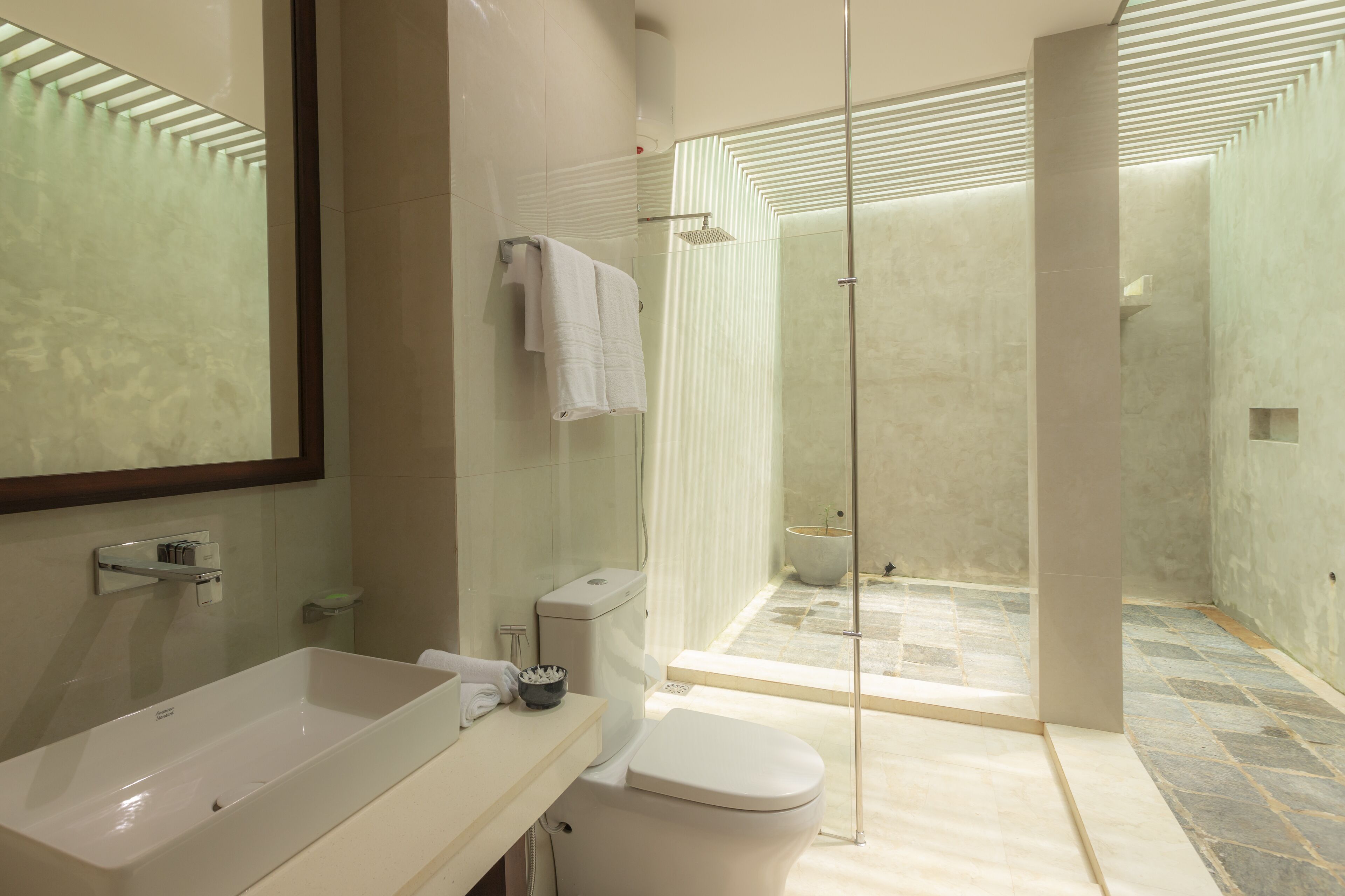 A modern bathroom with a large sink, toilet, and shower area.