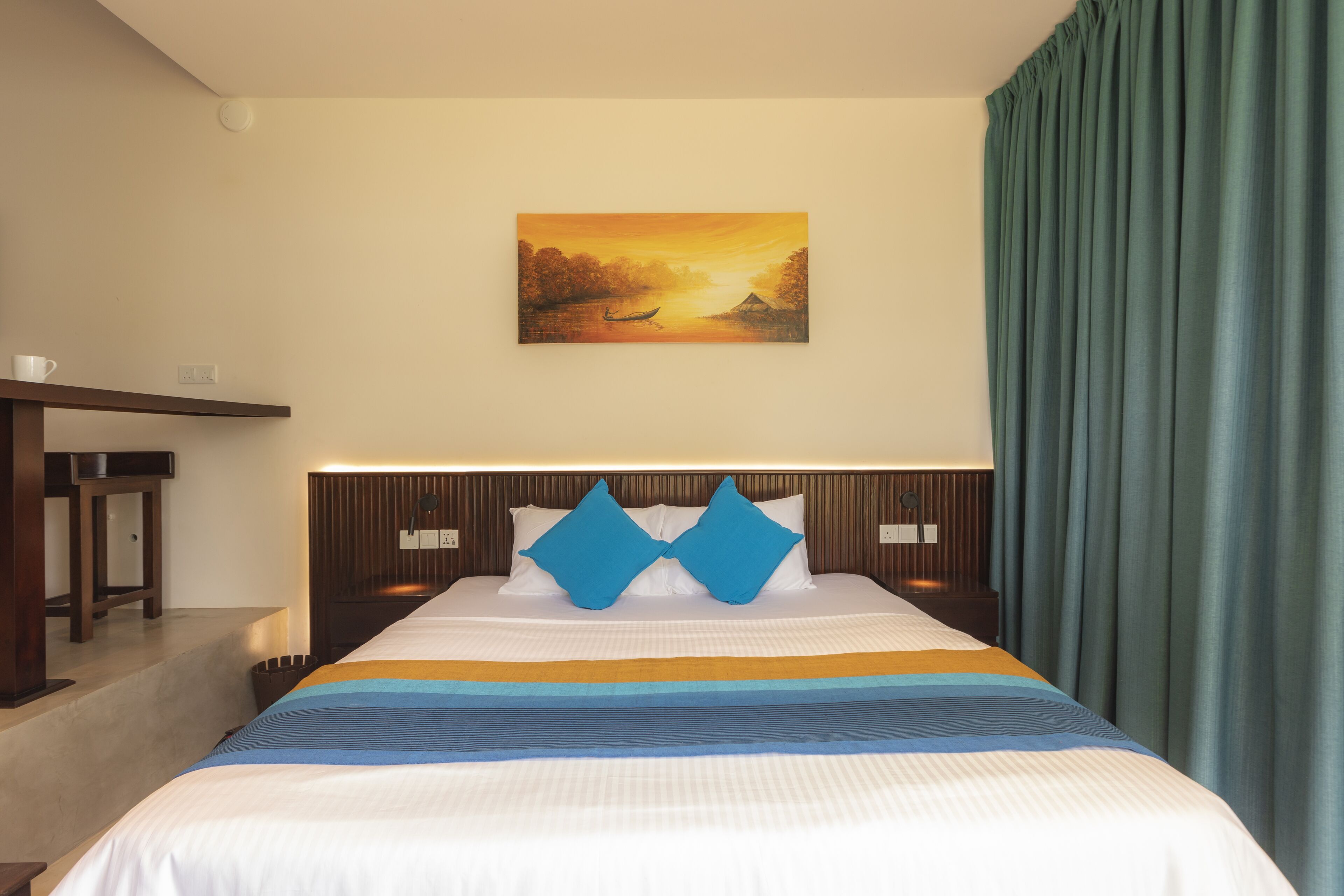 A hotel room with a bed, a painting on the wall, and a view of the outdoors.