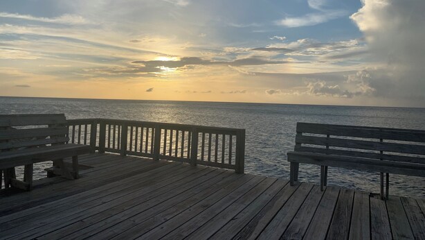 A wooden pier with benches overlooking a calm sea during sunset. - BEACHFRONT CASITA Snorkel & explore this amazing reef~ Experience Caribbean Life (Sandy Bay)
