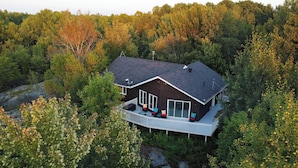 Ein Haus mit einer großen Terrasse, umgeben von dichtem Wald.