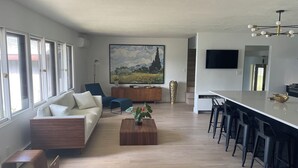 Una sala de estar moderna con un sofá, una mesa de centro y un cuadro en la pared.