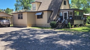 Ein zweistöckiges Haus mit überdachter Veranda, Garage und Auffahrt.