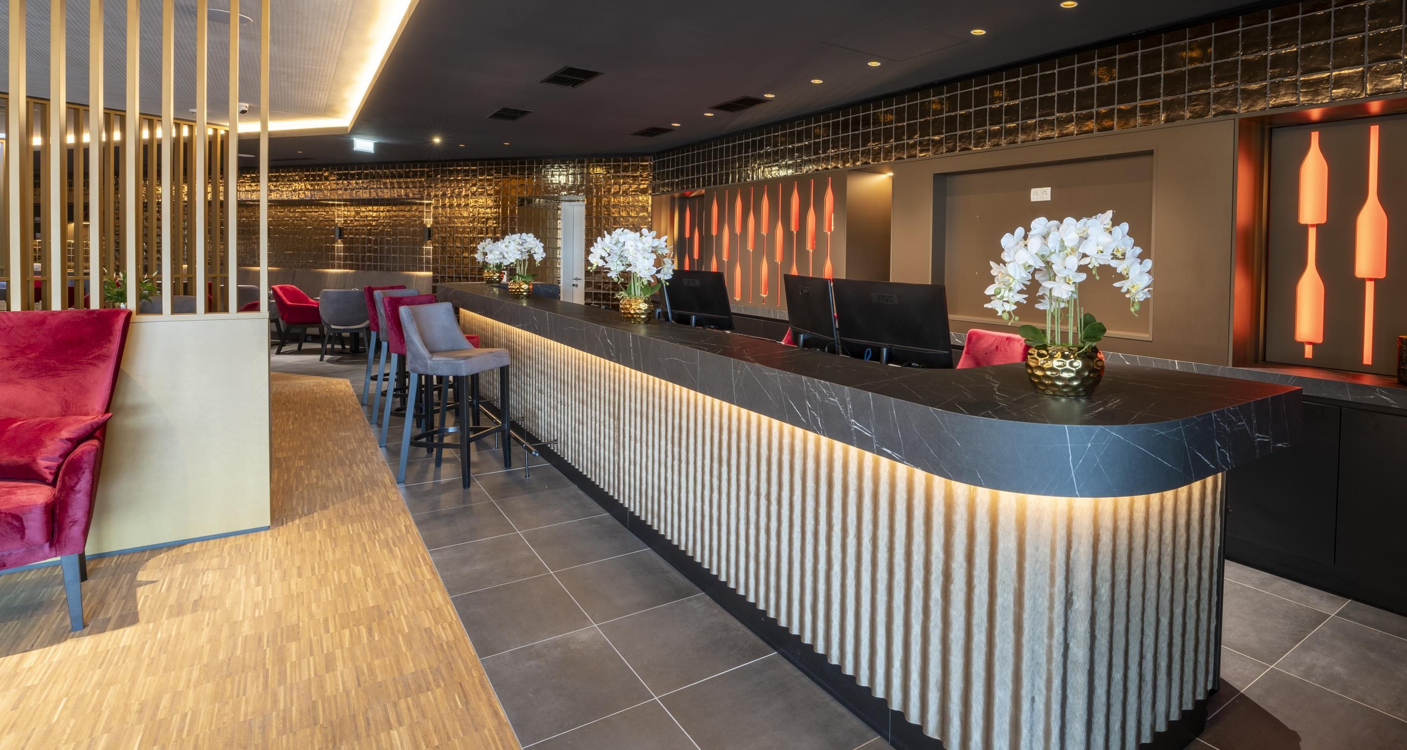 A modern reception area with a curved counter, seating, and decorative elements.