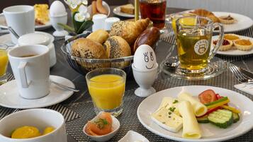 Un'impostazione per la colazione con diversi cibi, un teiera e una tazza di tè.
